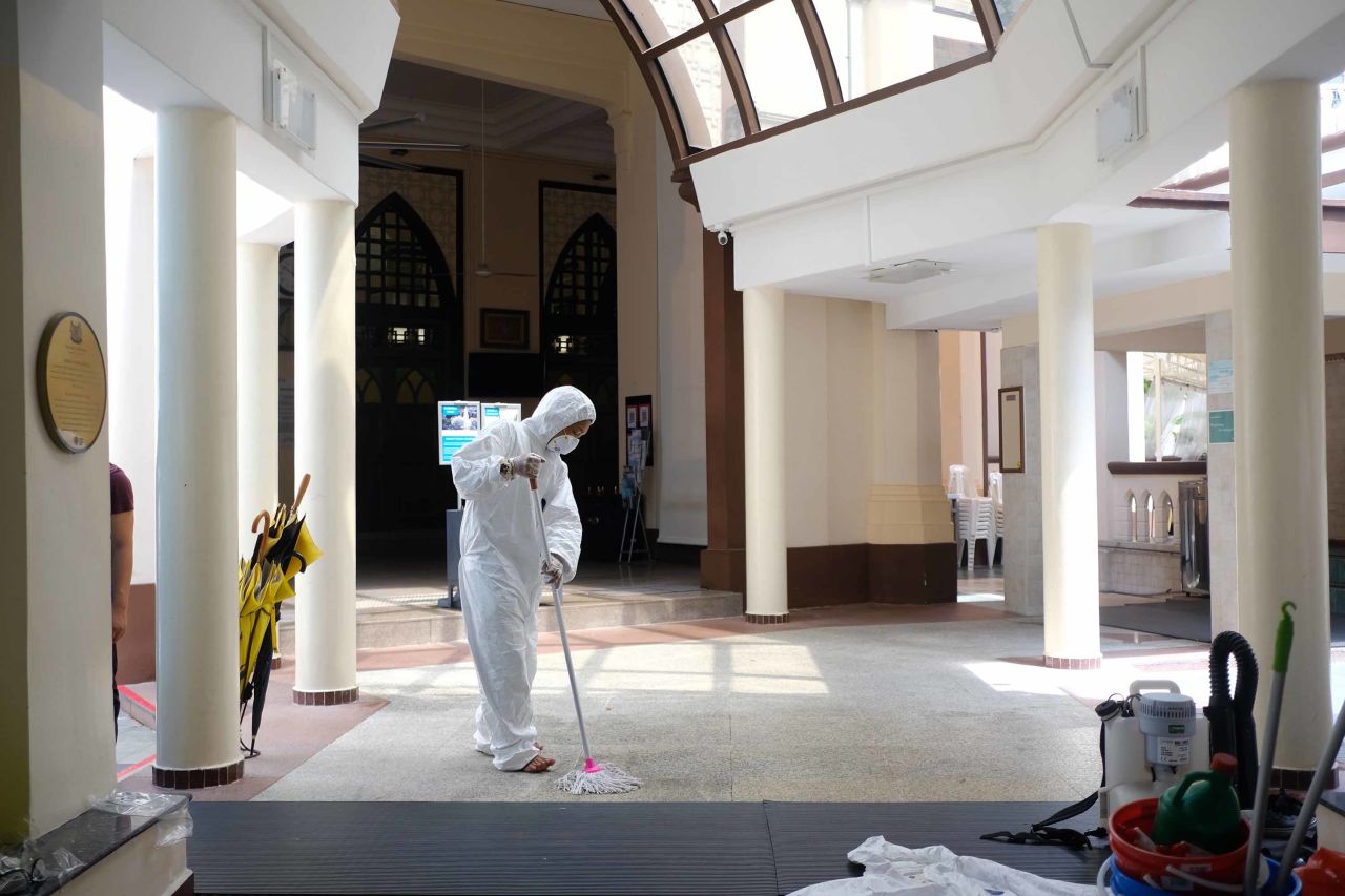 A working wearing protective gear mops the floor inside the Hajjah Fatimah mosque in Singapore on March 13.