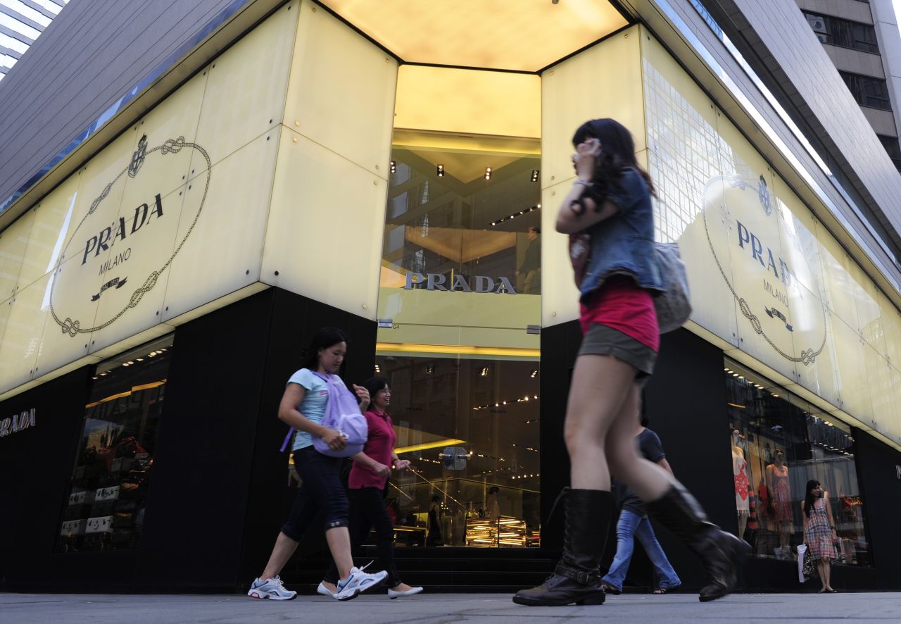 Pedestrians walk past a Prada shop in Hong Kong.