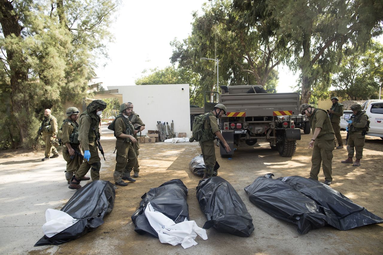 Israeli soldiers remove the bodies of civilians, who were killed days earlier in an attack by Palestinian militants in Kfar Aza, Israel, on October 10.