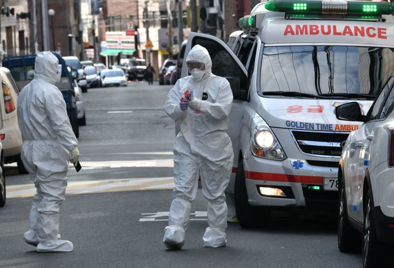 South Korean medical workers wearing protective gear carry samples as they visit the residence of people with suspected symptoms of the  coronavirus, near the Daegu branch of the Shincheonji religious group on February 27, 2020. (Photo by JUNG YEON-JE/AFP via Getty Images)