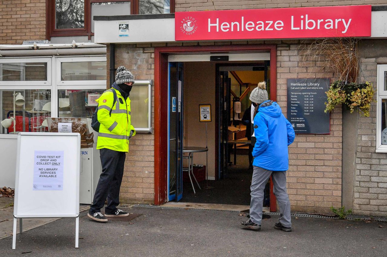 People wait outside a coronavirus surge testing center at a library in Bristol, England, on February 9, following the identification of a mutated variant in the region. 