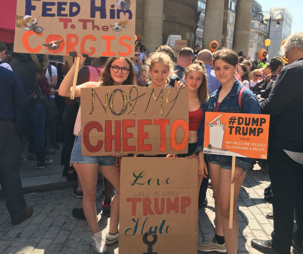 This group of teenagers brandish a sign which reads: Feed him to the corgis!” Trump is scheduled to meet Queen Elizabeth and perhaps, her corgis, at Windsor Castle later today.