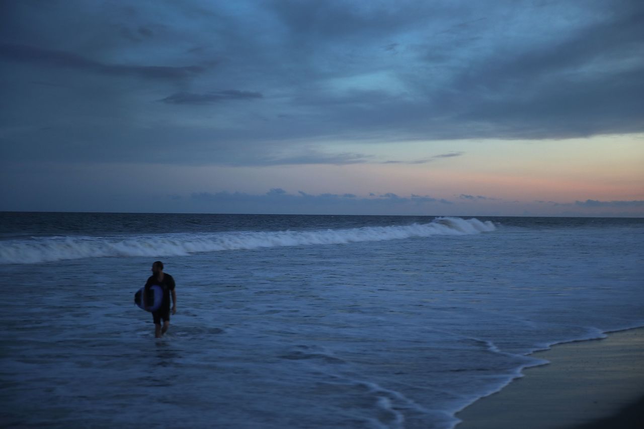 A surfer enjoys the waves ahead of the arrival of Hurricane Florence on Wednesday in Myrtle Beach,.