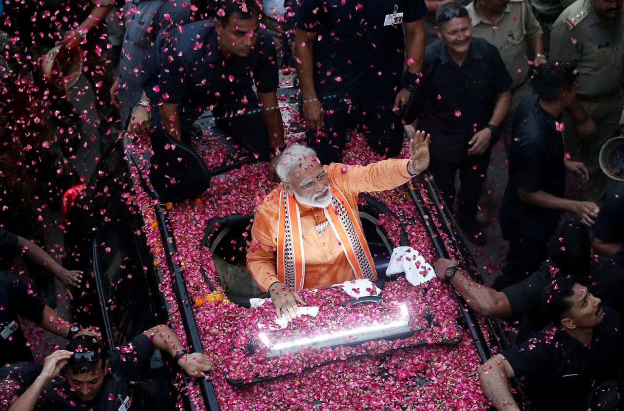 India's Prime Minister Narendra Modi waves towards his supporters during a roadshow in Varanasi, on April 25, 2019.