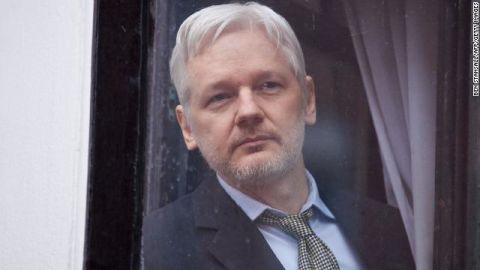 File photograph of Assange peering through the balcony window of the Ecuadorian embassy in central London on February 5, 2016.