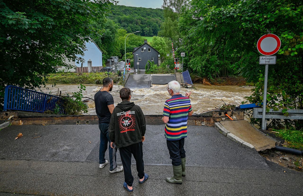 People look at a destroyed railway crossing and damages caused by the floods of the Volme river on Thursday in Priorei in western Germany.