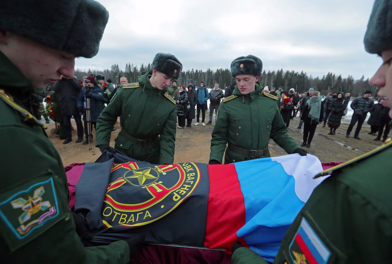 Military academy cadets cover the coffin with flags during the funeral of a Wagner Group mercenary killed in Ukraine at a cemetery in St. Petersburg, Russia, on December 24, 2022. 