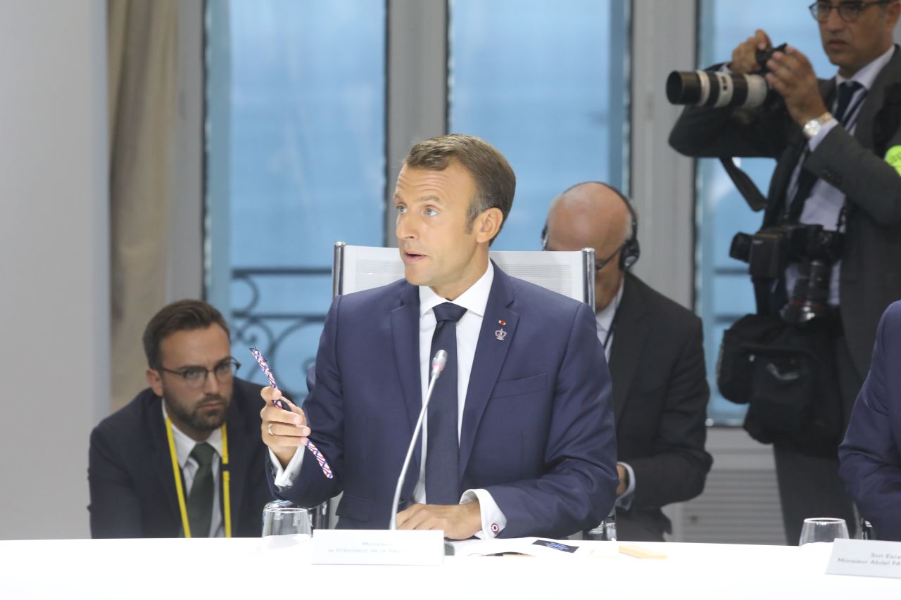 Macron shows off the watch made from recycled plastic. 