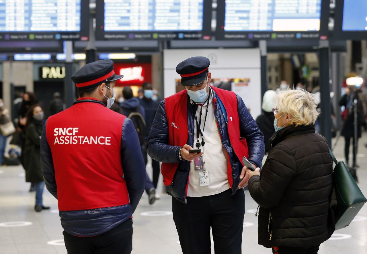 Rail company employees wear protective face masks at the Gare Saint Lazare railway station in Paris on Monday.
