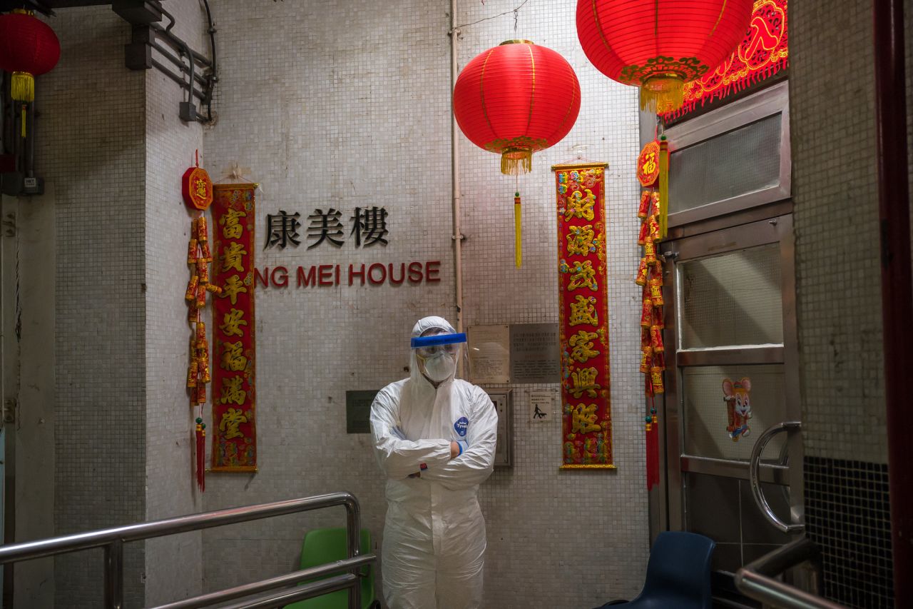 An official wearing protective gear stands guard outside an entrance to the Hong Mei House residential building at Cheung Hong Estate in Hong Kong's Tsing Yi district on Tuesday.