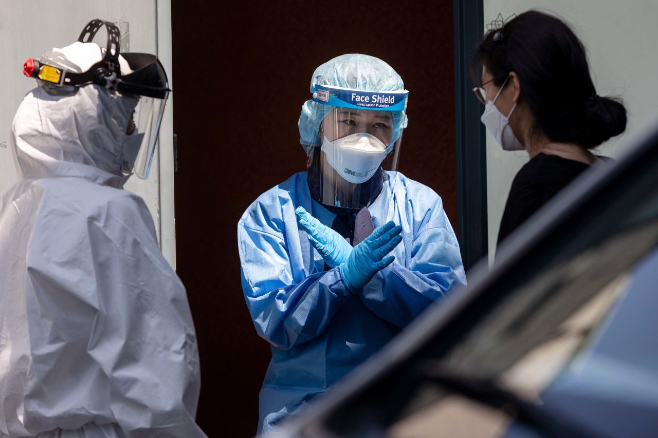 Medical workers speak with a person at a temporary coronavirus testing station in Seoul, South Korea, on June 11.