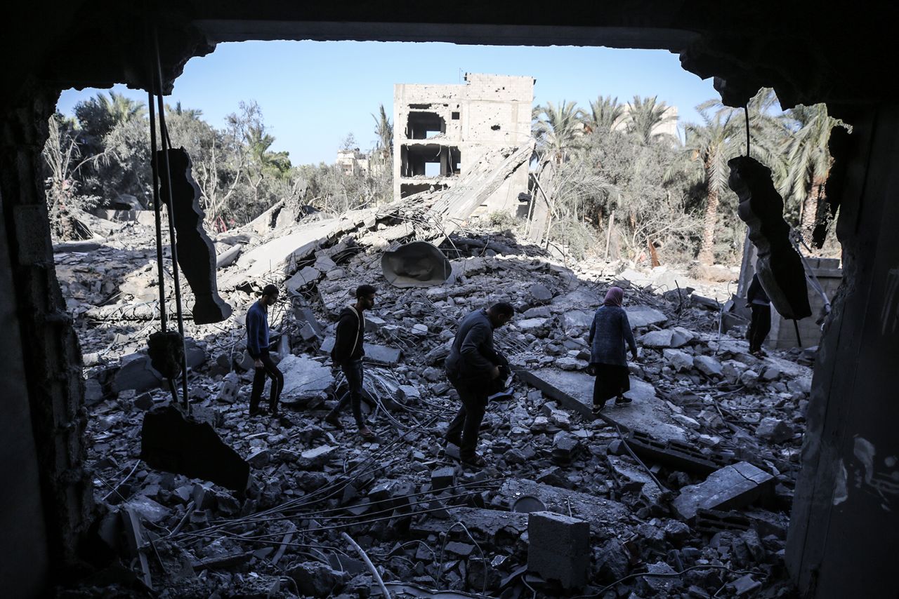 Palestinians walk through the rubble of a destroyed building following an Israeli strike in Deir Al Balah, Gaza on November 23.