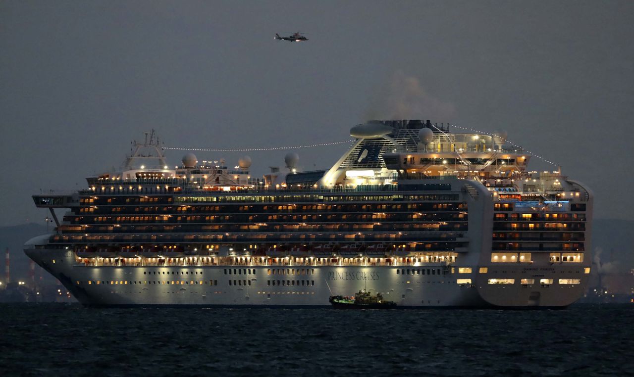 A small boat is pictured next to the Diamond Princess cruise ship with over 3,000 people as it sits anchored in quarantine off the port of Yokohama on February 4.