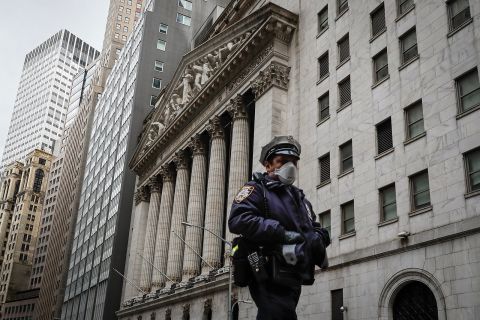 An NYPD officer walks along a sparsely populated Wall Street in New York City, NY on May 1.
