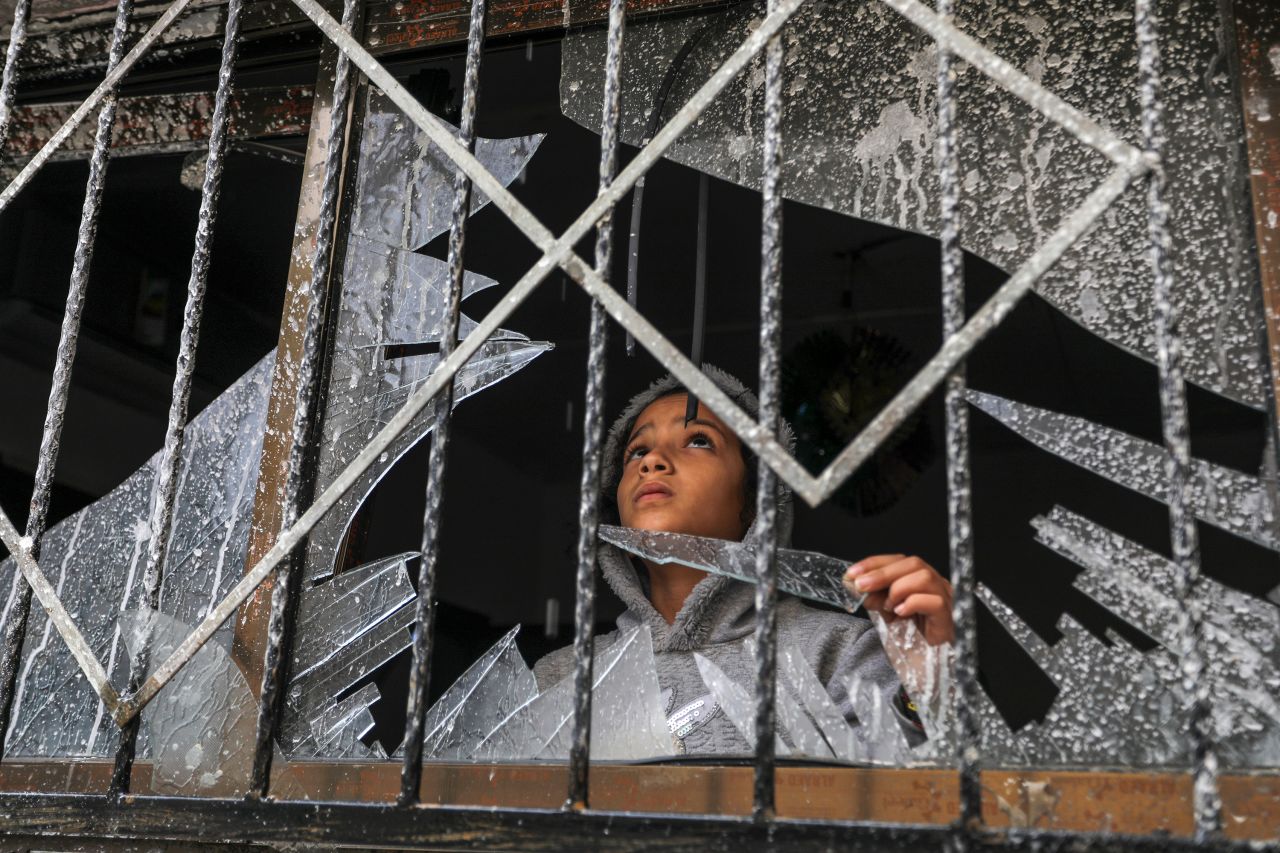 A Palestinian child looks through a broken window of a destroyed building, in Rafah, Gaza on November 15.