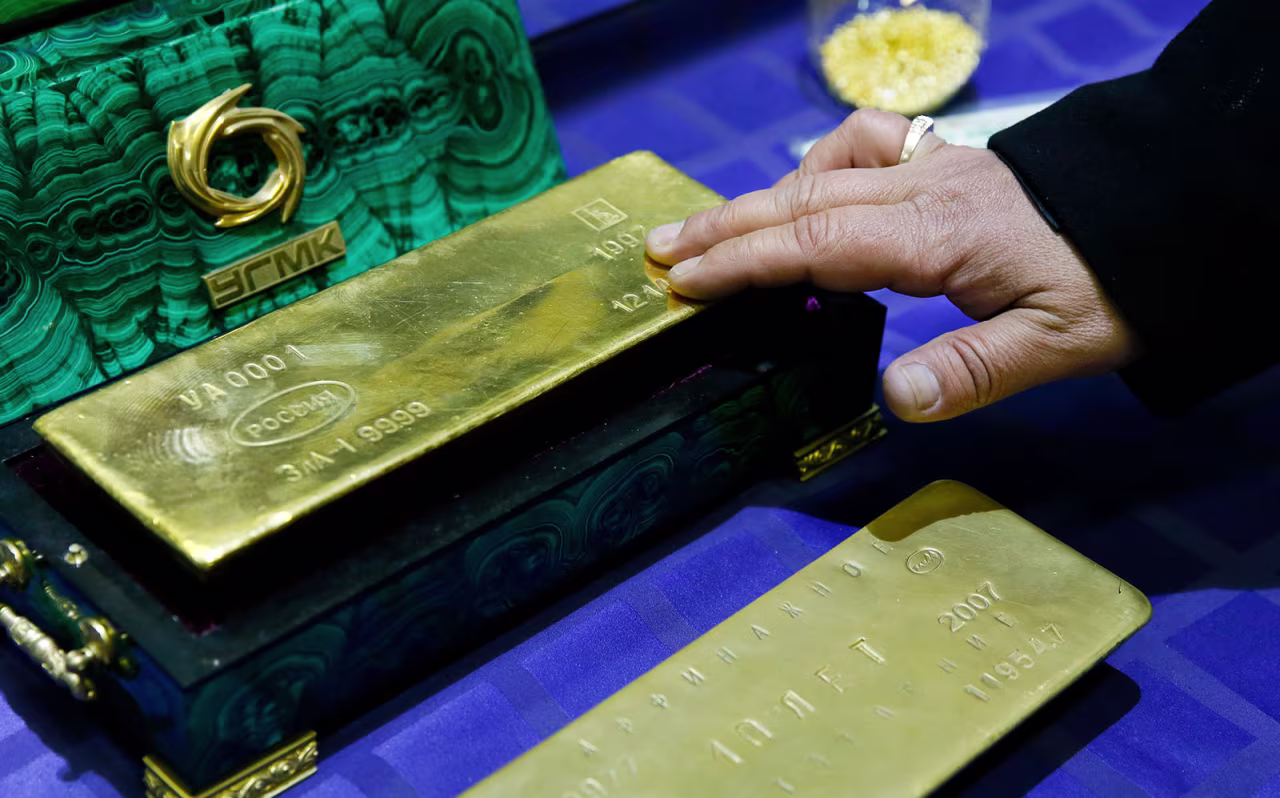An employee displays a gold bar at a gold refining workshop of the Uralelektromed Joint Stock Company plant in Verkhnyaya Pyshma, Russia, on October 17, 2014. 