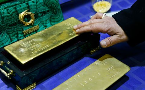 An employee displays a gold bar at a gold refining workshop of the Uralelektromed Joint Stock Company plant in Verkhnyaya Pyshma, Russia, on October 17, 2014. 
