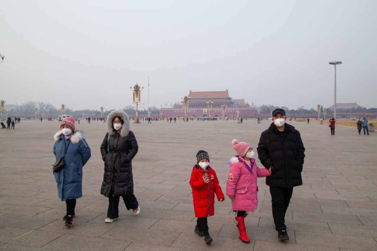 A family wearing masks are seen in Tiananmen Square on January 26, 2020 in Beijing, China. 