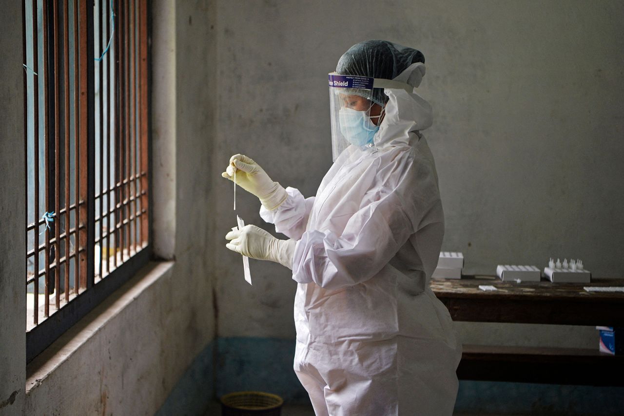 A health worker wearing protective gear works on the nasal swab samples of election counting agents at Siliguri college counting center in Siliguri on April 30.
