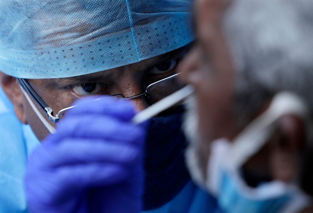 A health worker takes a nasal swab sample to test for Covid-19 at a market place in Mumbai, India, on March 18.