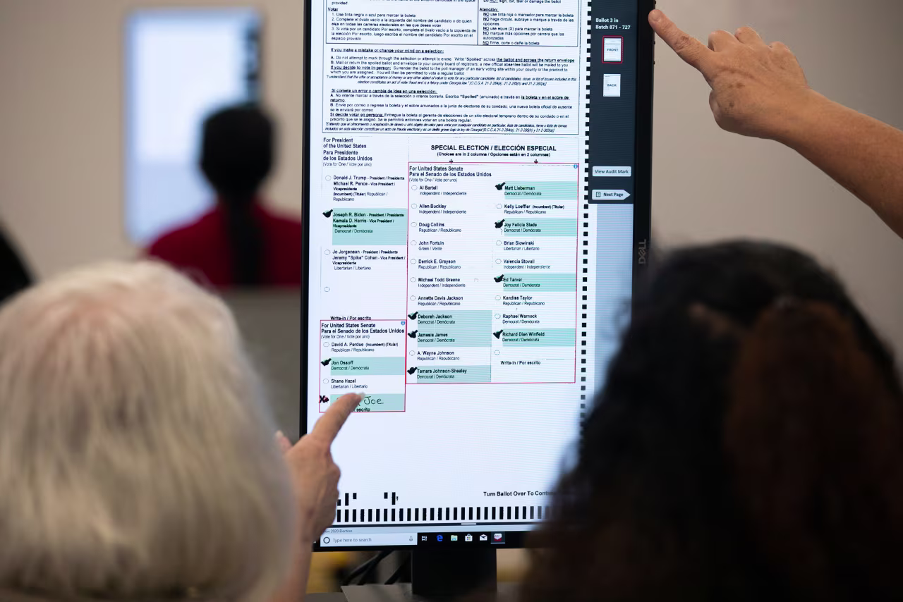 Members of the Gwinnett County adjudication review panel look over ballots on November 8 in Lawrenceville, Georgia. 