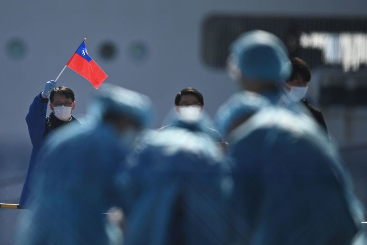 A man holds a Taiwan flag as passengers disembark from the Diamond Princess cruise ship in Yokohama, Japan, on February 21.