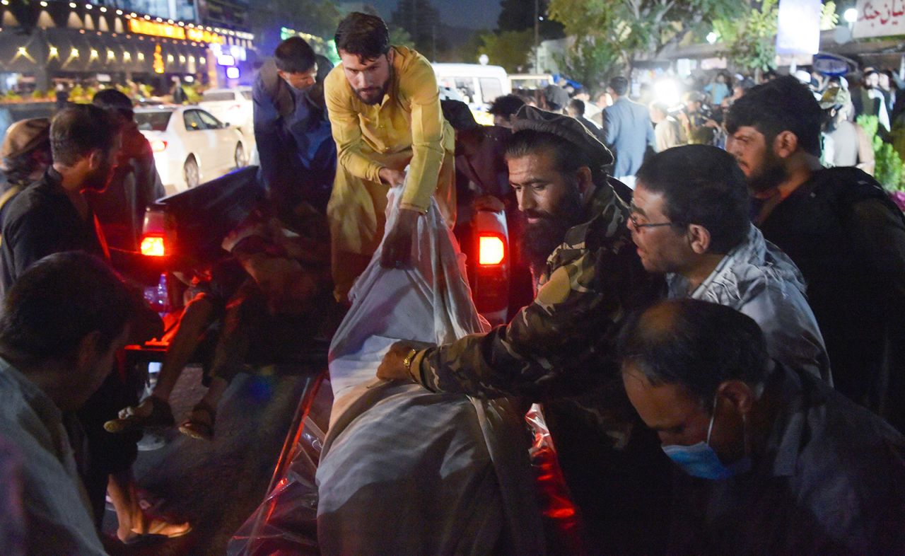 Volunteers and medical staff unload bodies from a pickup truck outside a hospital after explosions in Kabul on August 26.