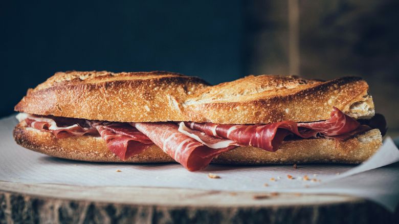 2E6XW9W Horizontal shot of a bread baguette filled with jamon iberico or iberian ham
