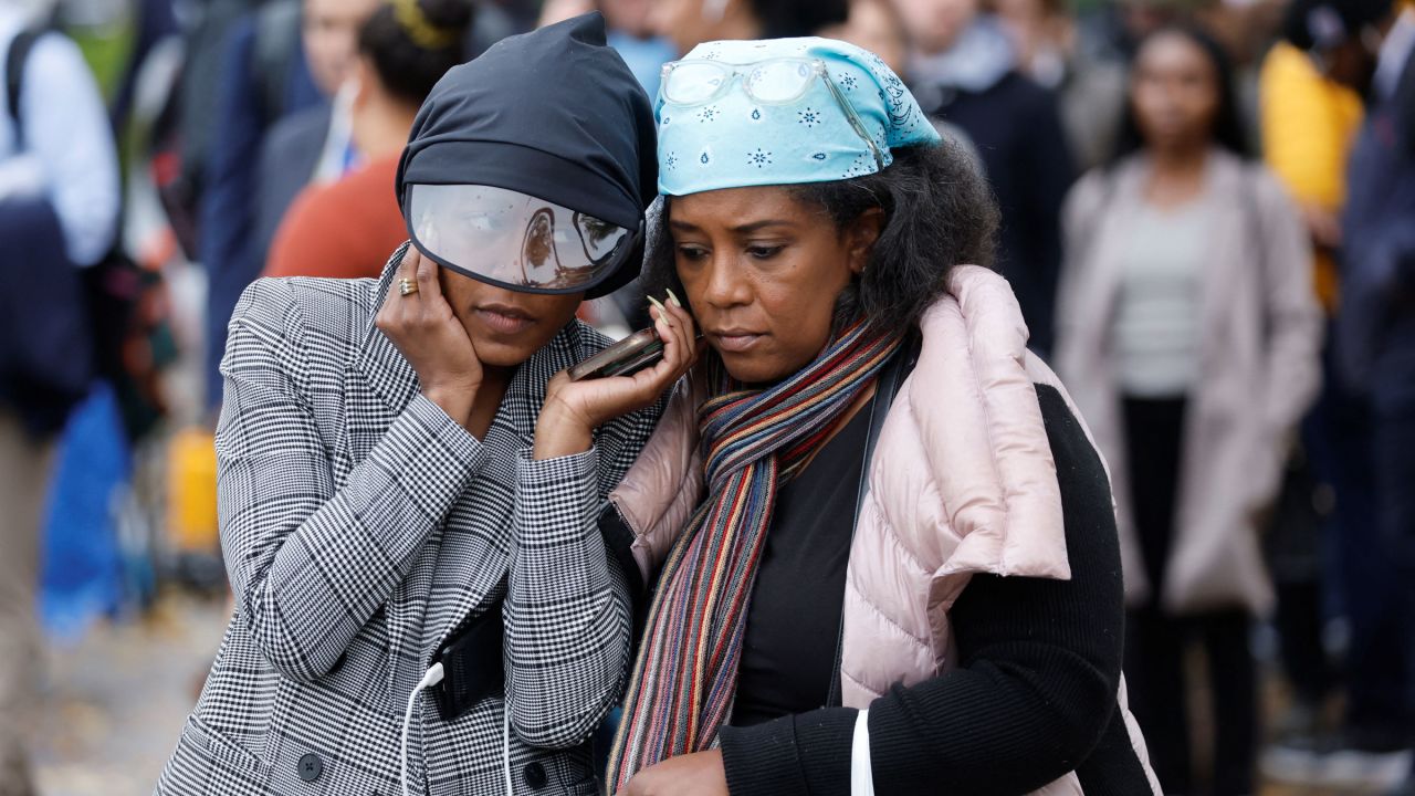 Taylor Dumpson and her mother, Kimberly, listen to Supreme Court arguments over their phone as they wait in line in hopes of being seated inside the Supreme Court on Monday.