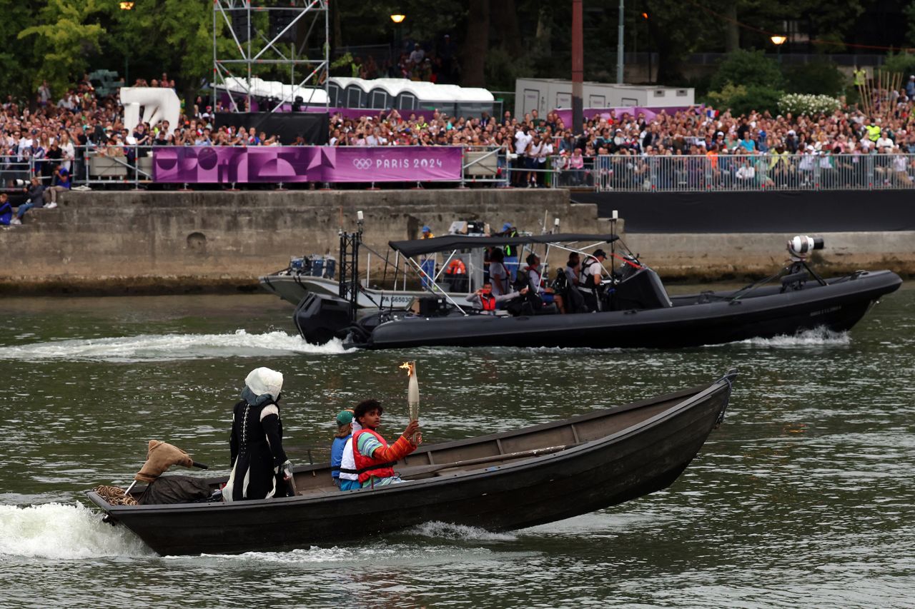 The Olympic torch is carried on a boat along the river Seine at the start of the opening ceremony?today.