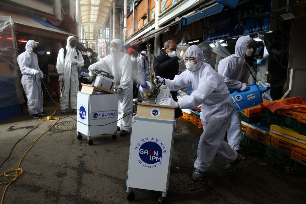 Workers spray antiseptic solution at a market on February 26 in Seoul, South Korea. 