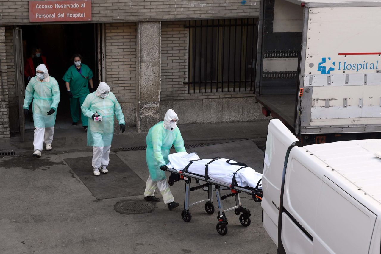 Health workers transport a body on a stretcher outside the Gregorio Maranon hospital in Madrid on March 25.