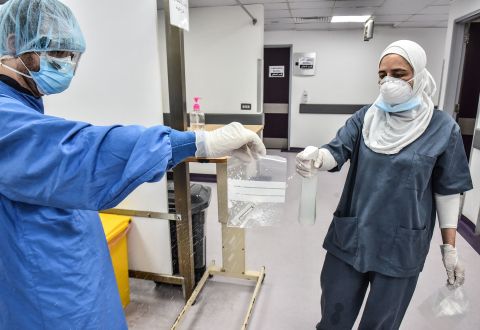 Health workers handle a coronavirus test at Rafik Hariri University Hospital in Beirut, Lebanon, on August 11.