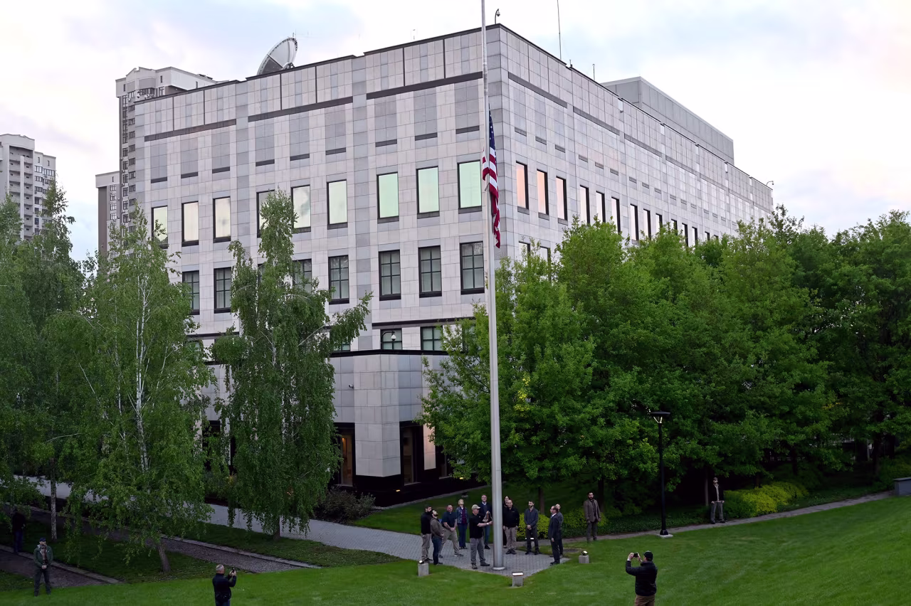 Employees raise a flag outside the US embassy in Kyiv, Ukraine, on May 18, as the embassy reopens after being closed for three months due to the Russian invasion. 