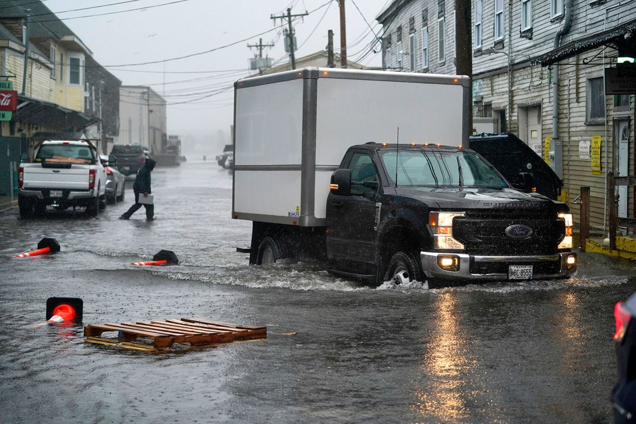 A delivery truck drives through floodwaters on the Portland, Maine, waterfront on December 23.