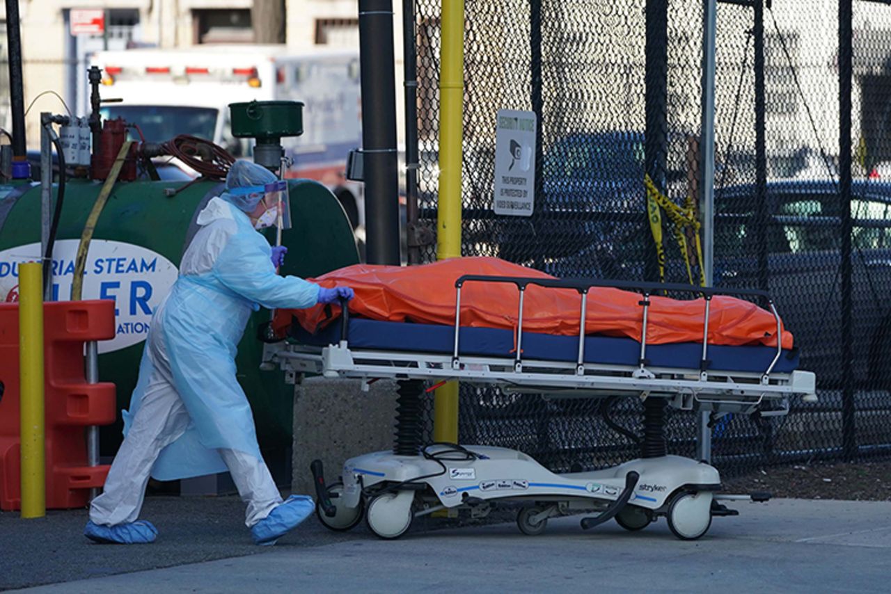 A body is moved to a refrigerator truck serving as a temporary morgue outside of Wyckoff Hospital in Brooklyn on April 4, in New York.