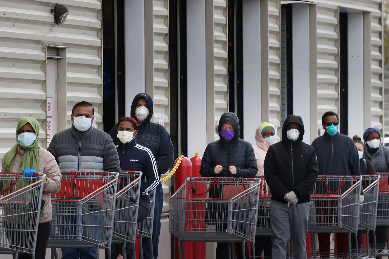 Customers wear face masks while standing in line at a Costco store in Wheaton, Maryland, on April 16.