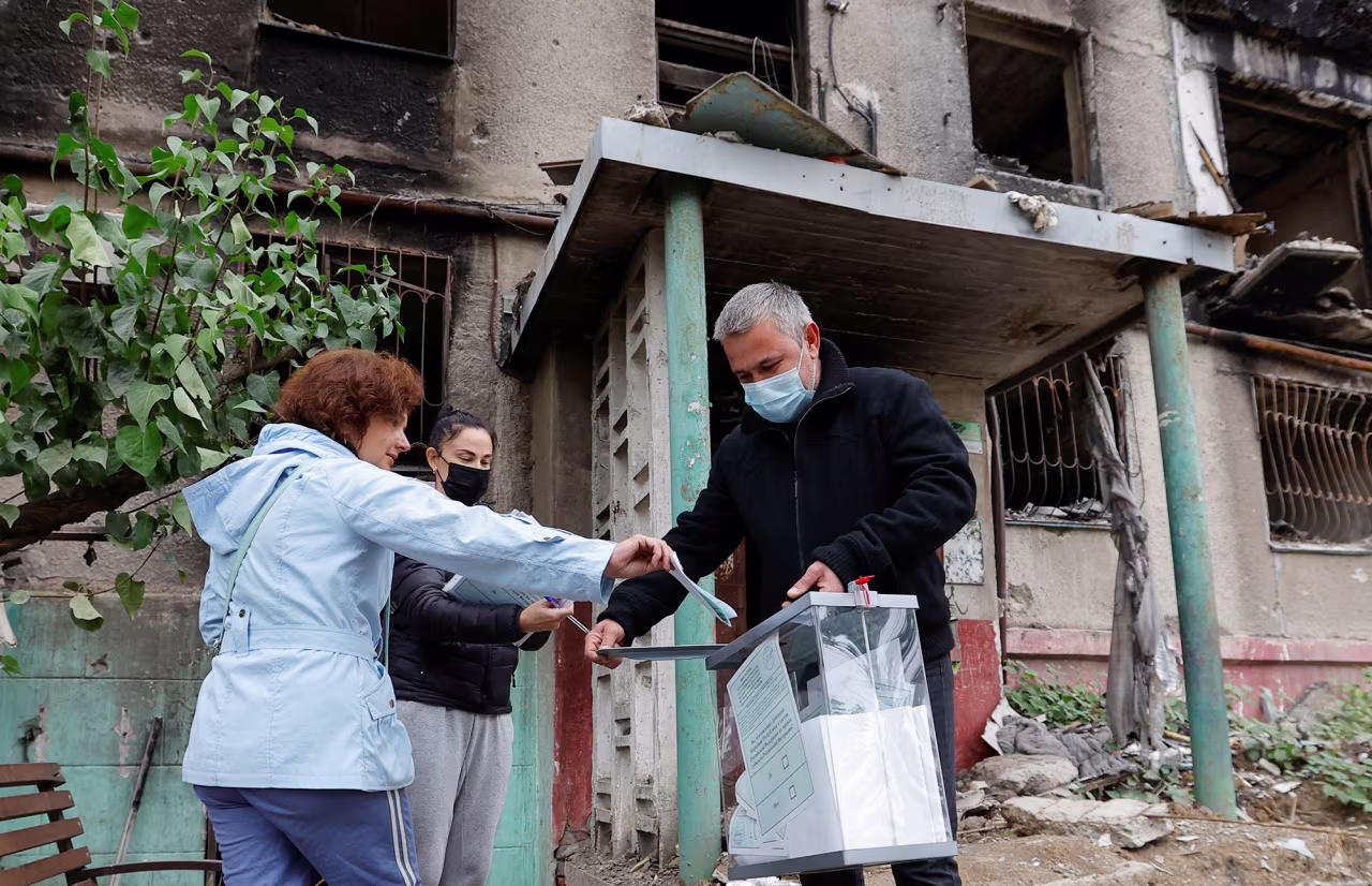 Resident cast a ballot into a mobile ballot box carried by members of an electoral commission on the second day of a referendum on the joining of the self-proclaimed Donetsk People's Republic (DPR) to Russia, in Mariupol, Ukraine, on September 24.