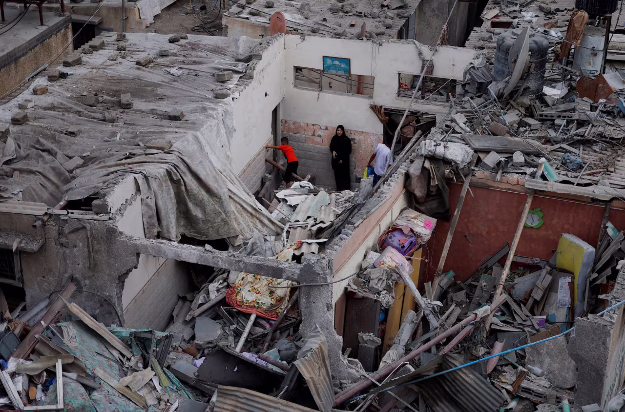 Palestinians check damage at the site of Israeli strikes on houses in Khan Younis on Sunday.