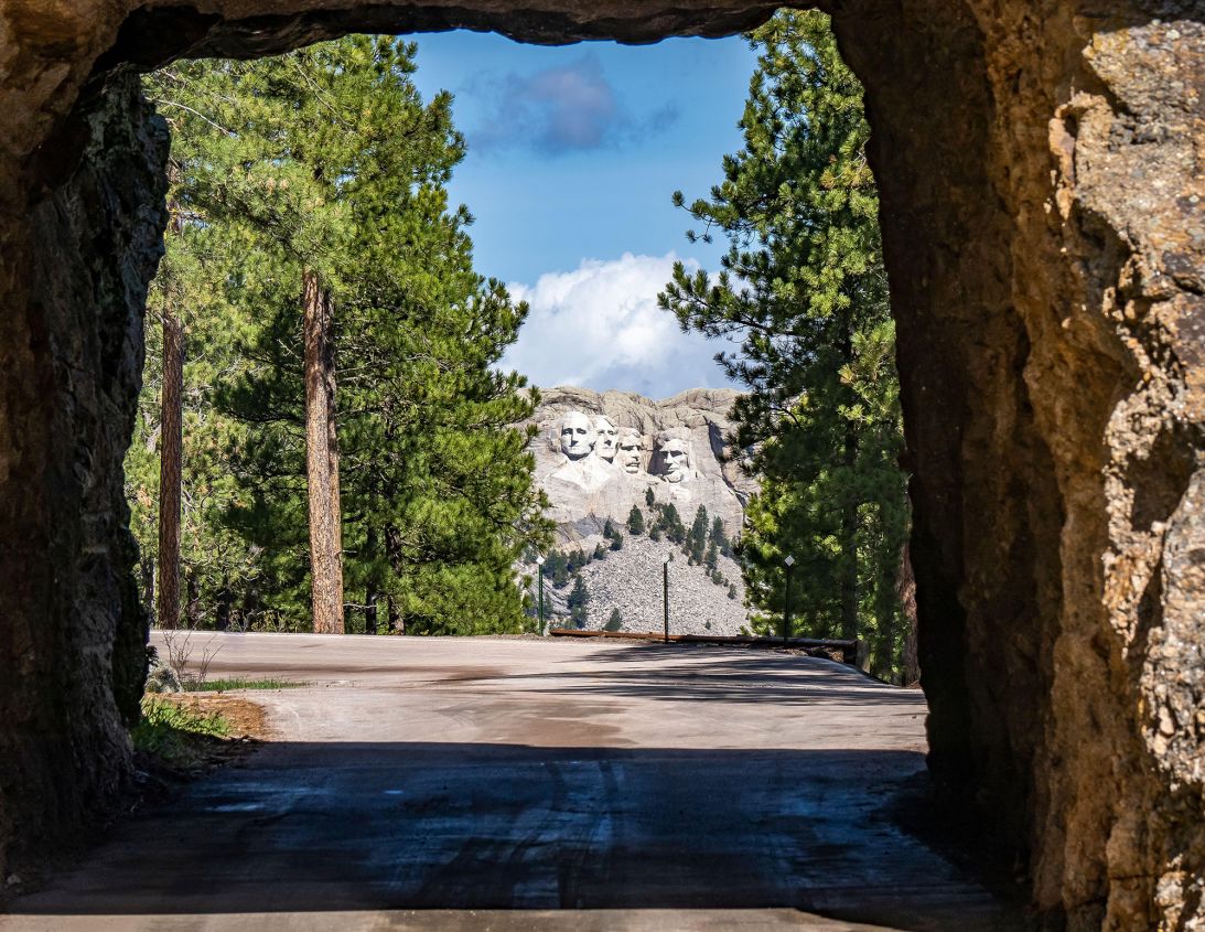 Several tunnels along the Peter Norbeck National Scenic Byway frame the four faces on Mount Rushmore in the distance.