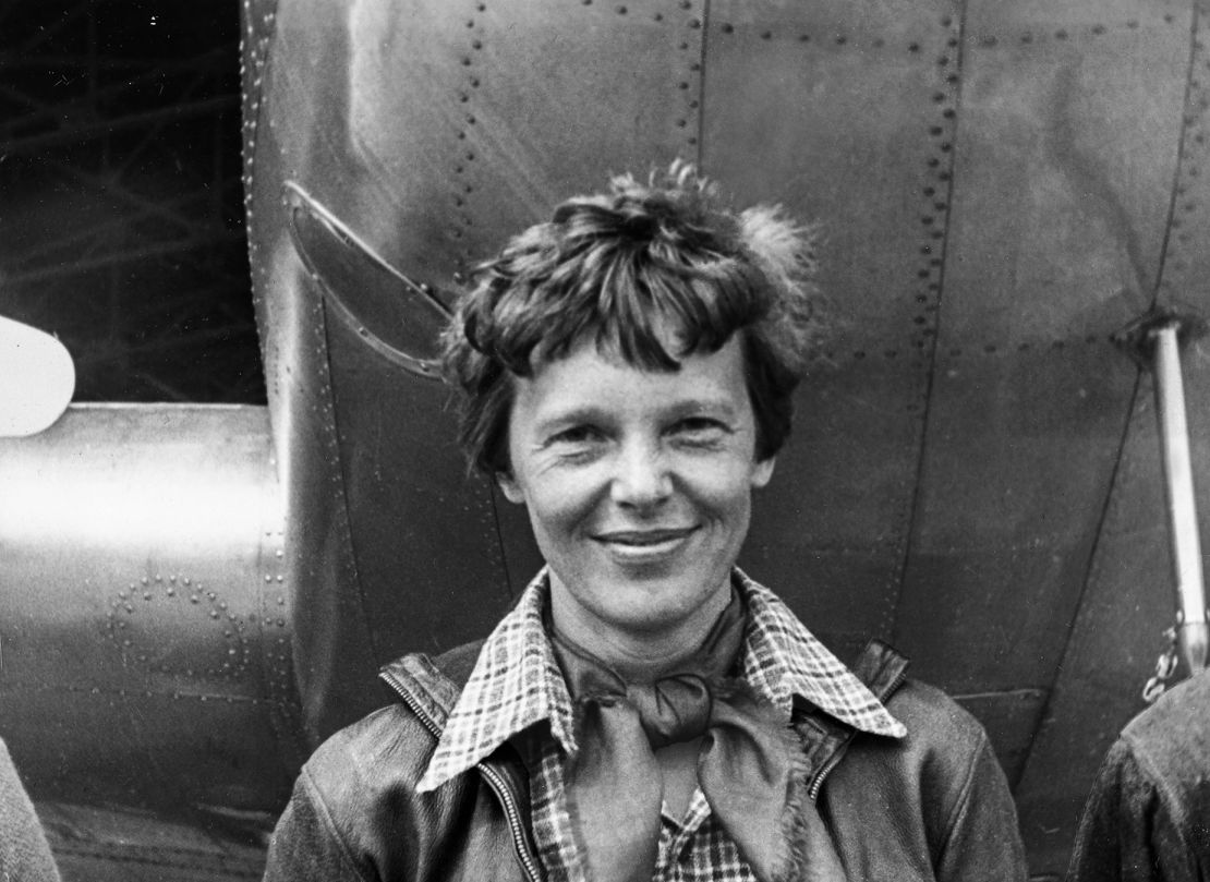 Amelia Earhart is shown standing under the nose of her Lockheed Model 10-E Electra plane in 1937.