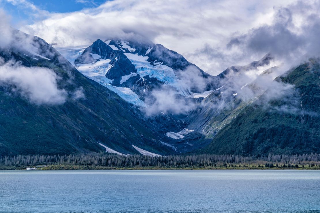 2T88T97 Moody clouds float over the Byron Glacier above Portage Lake in Chugach National Forest, Alaska.