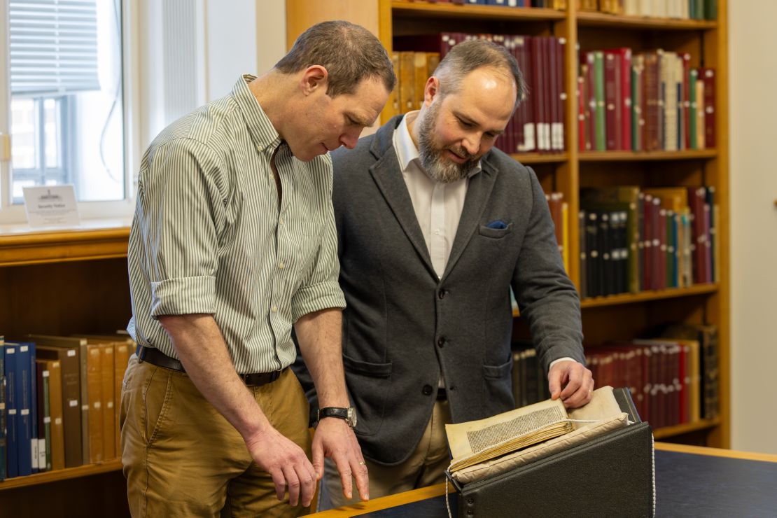 Study coauthors Dr. James Wade (left) and Dr. Seb Falk study the sermon mentioning the Song of Wade.