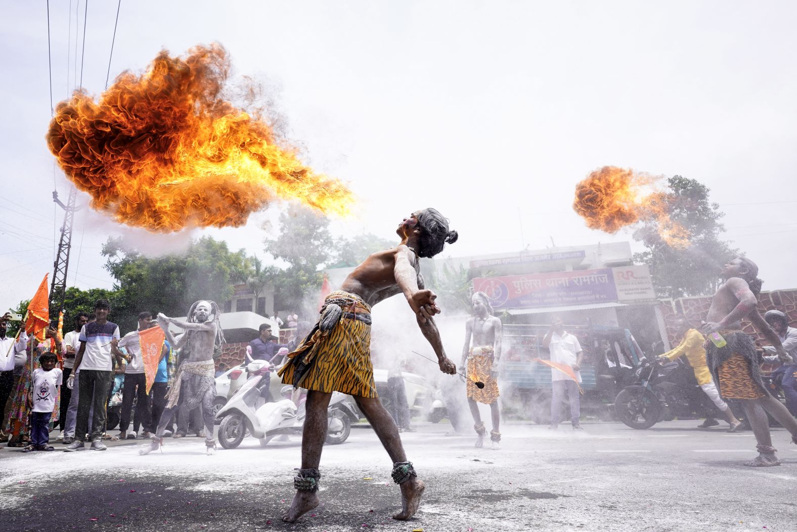 People perform a fire-breathing stunt as they take part in a religious procession during the Kanwar Yatra pilgrimage in Ajmer, India, on Tuesday, July 29.