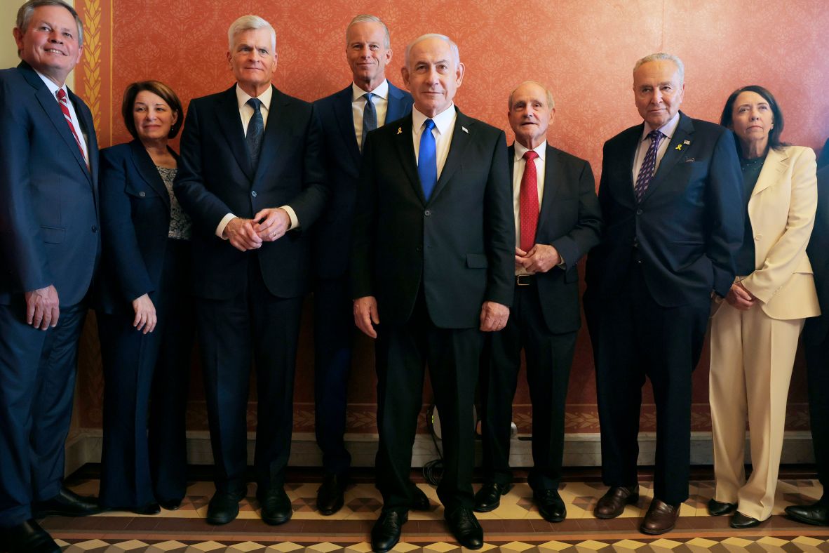 Israeli Prime Minister Benjamin Netanyahu, center foreground, poses for photographs before meeting with US senators in Washington, DC, on Wednesday, July 9. With Netanyahu, from left, are Montana Sen. Steve Daines, Minnesota Sen. Amy Klobuchar, Louisiana Sen. Bill Cassidy, Senate Majority Leader John Thune, Idaho Sen. Jim Risch, Senate Minority Leader Chuck Schumer and Washington Sen. Maria Cantwell.