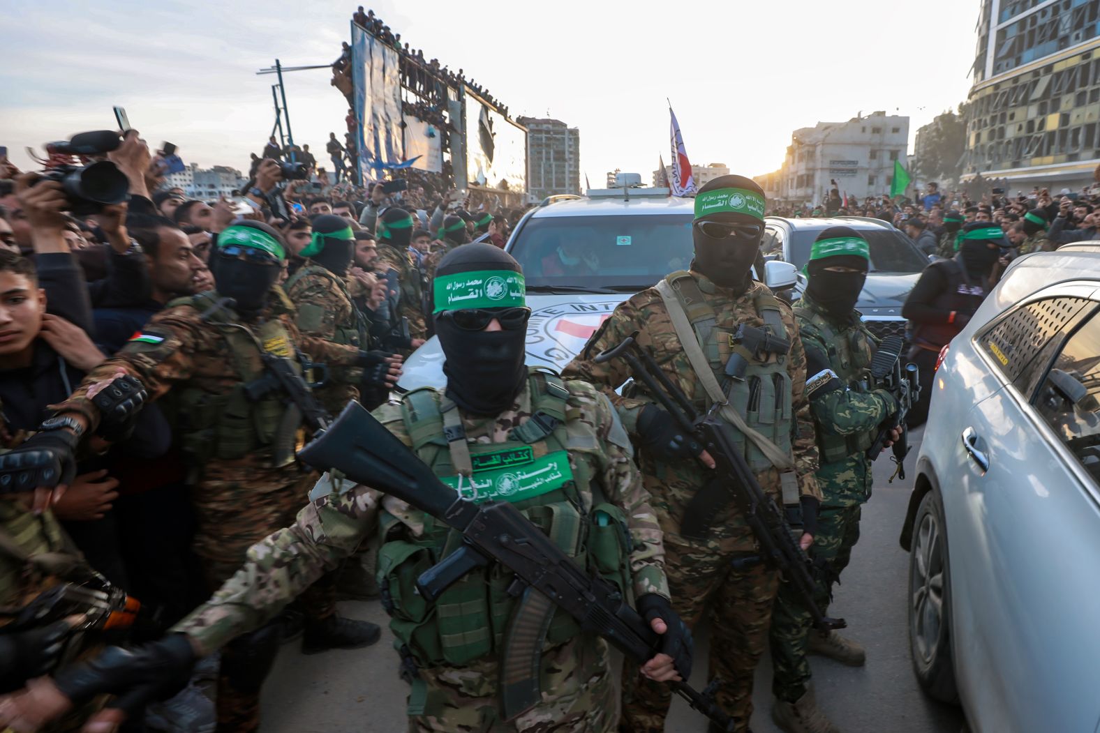 Hamas fighters escort a Red Cross vehicle in Gaza City to collect Israeli hostages who were released as part of ceasefire deal between Hamas and Israel on Sunday, January 19.