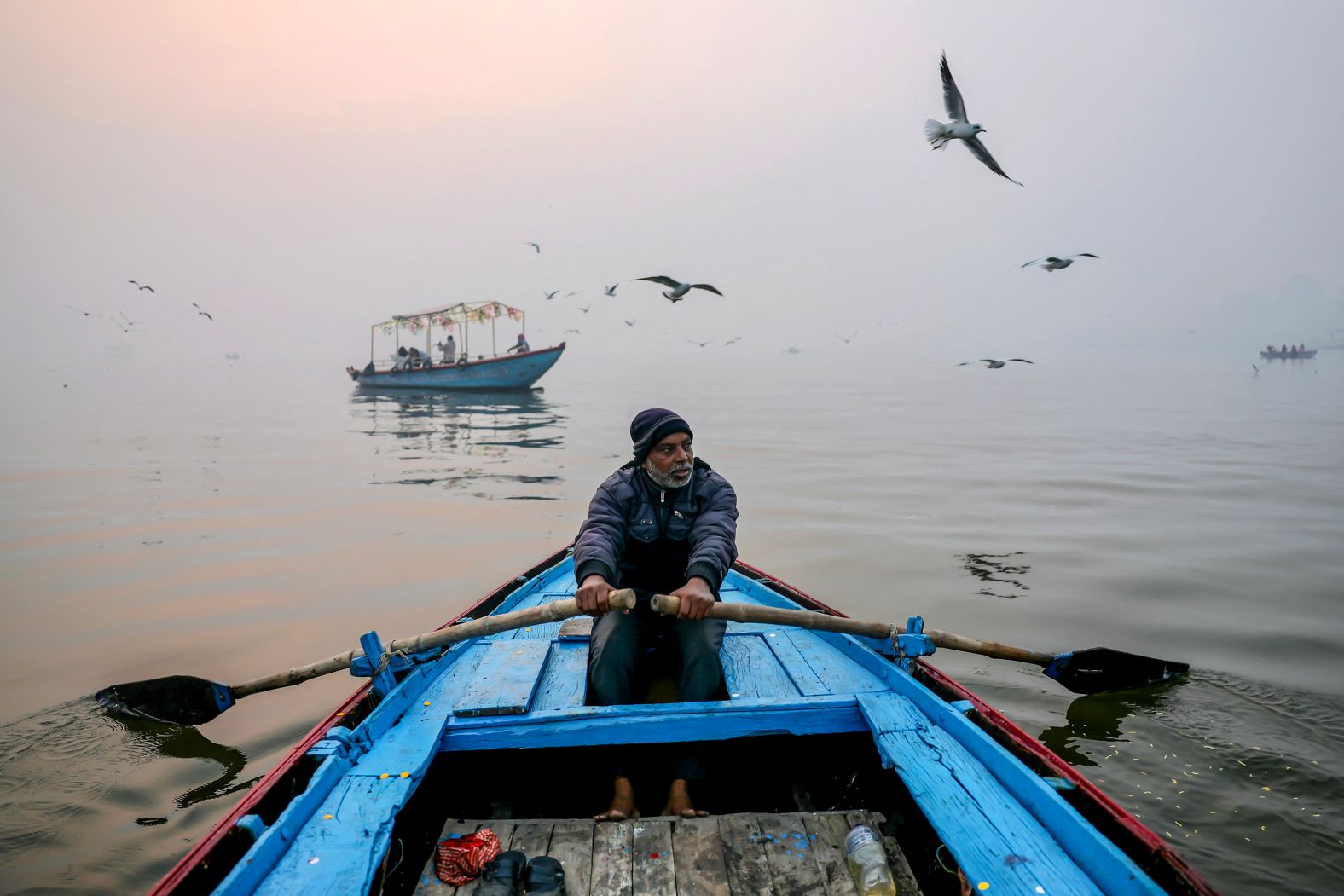 A man rows his boat across the Ganges River on a cold winter morning in Varanasi, India, on Friday, December 27.