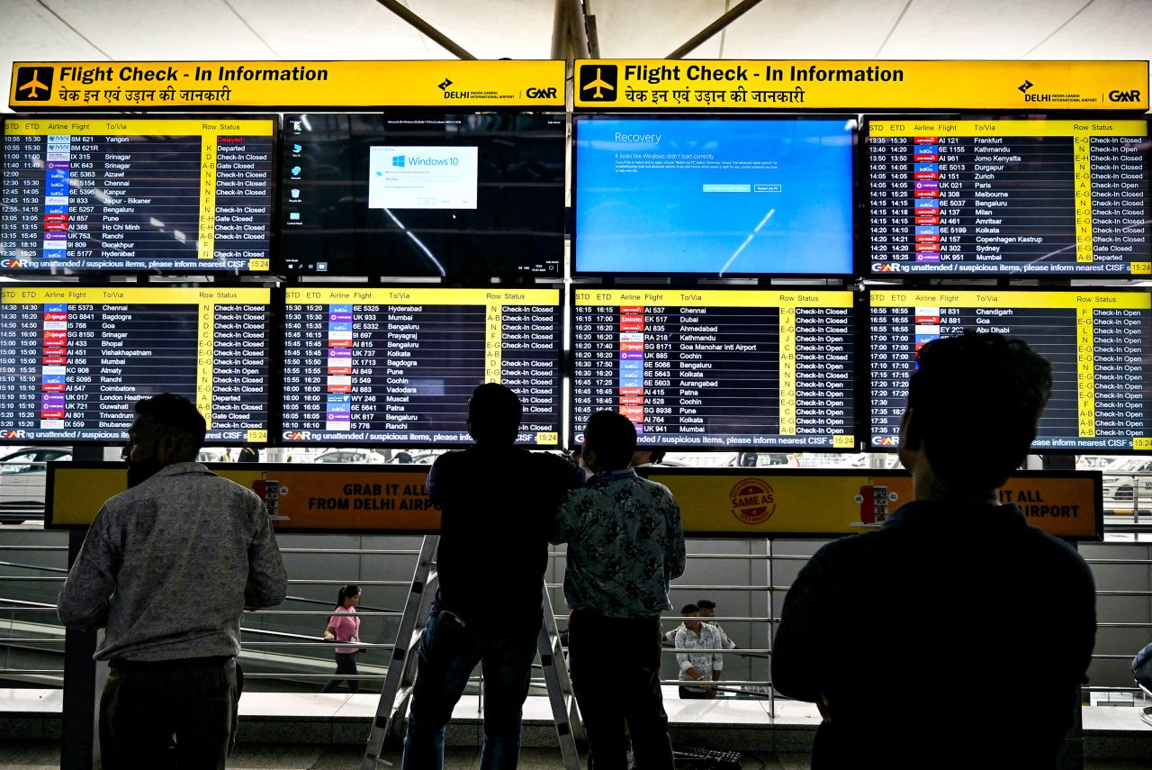 Screens display flight information and error messages during a technology outage at the Indira Gandhi International Airport in New Delhi on July 19.