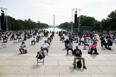 Attendees sit socially distanced at the 2020 March on Washington, officially known as the “Commitment March: Get Your Knee Off our Necks,” at the Lincoln Memorial on Friday in Washington.