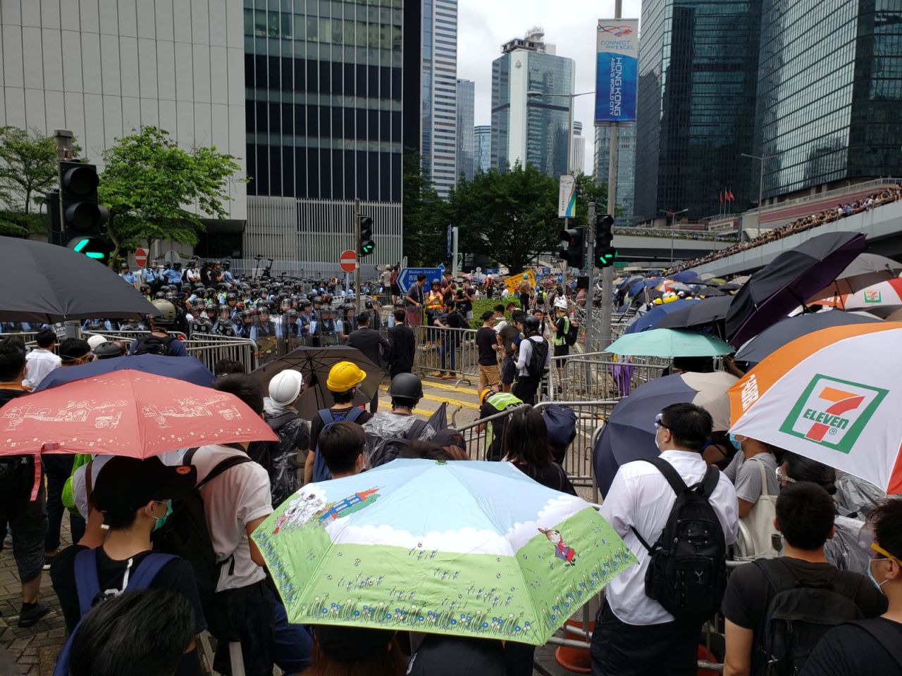 Protesters hand out anti-tear gear and masks by Tim Wa Avenue.